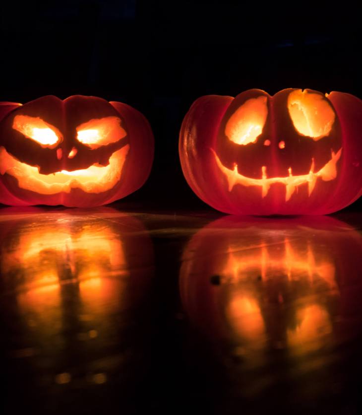two pumpkins with candles inside