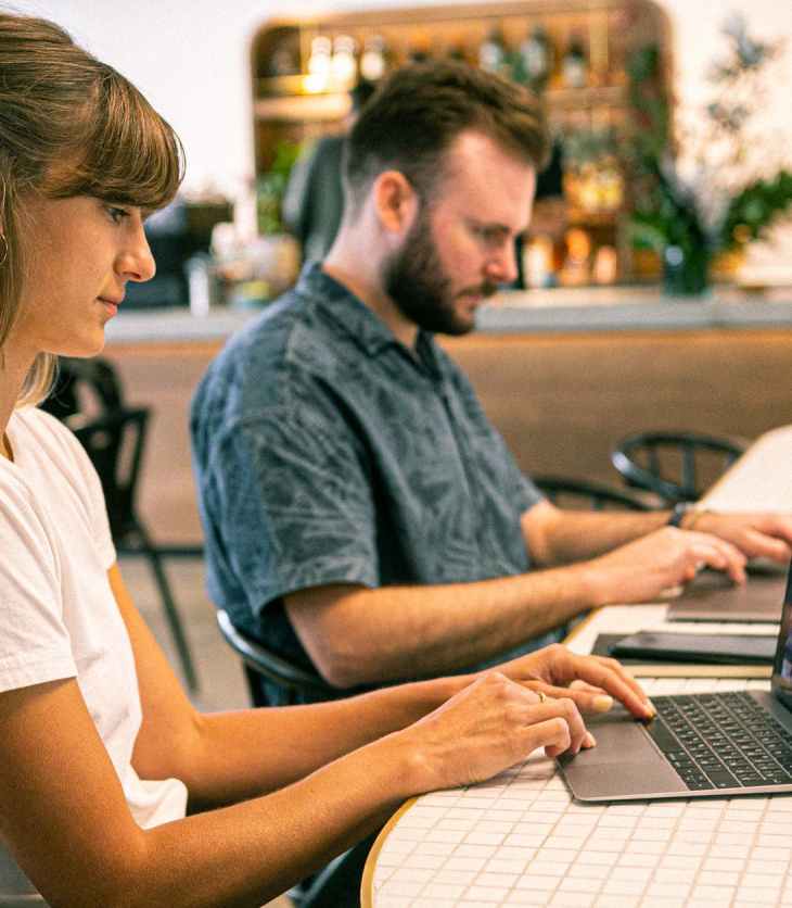 photo of woman and man freelancing, using their laptops