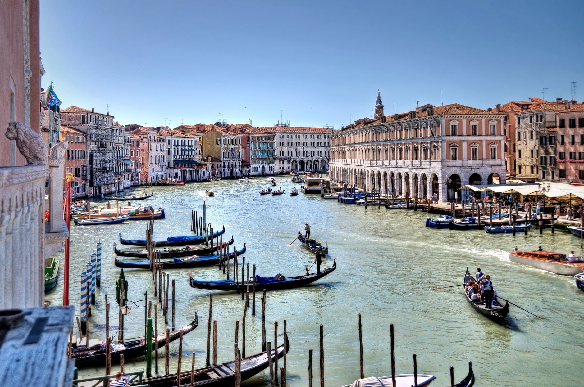 An image of gondolas on a big expanse of water, and tall buildings along the sides. Venice, Italy