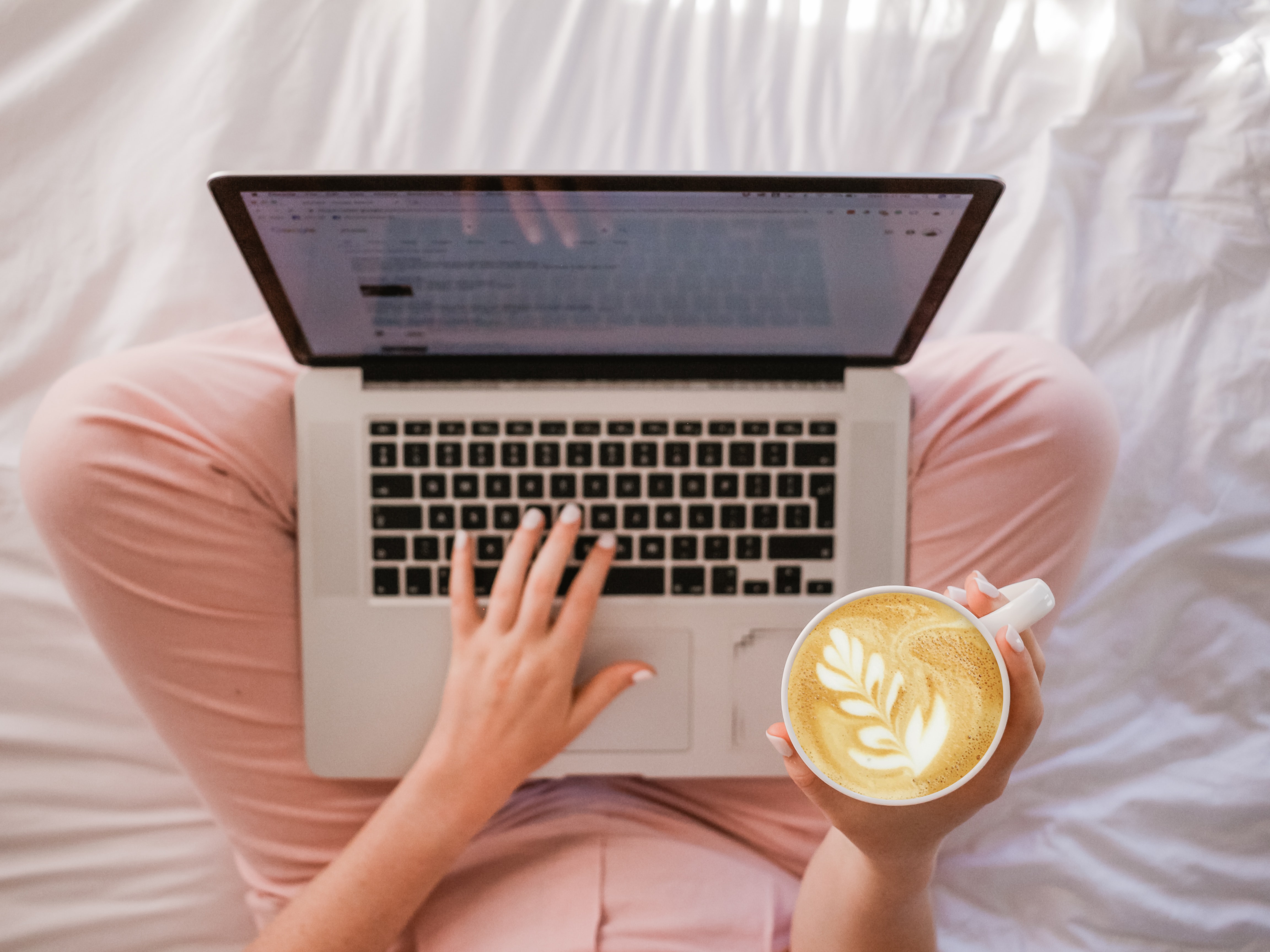 person sitting crossed leg with a coffee and a laptop- 6 things I love about being a freelancer
