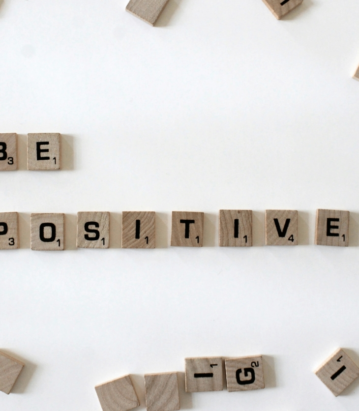 scrabble tiles spelling out "be positive"